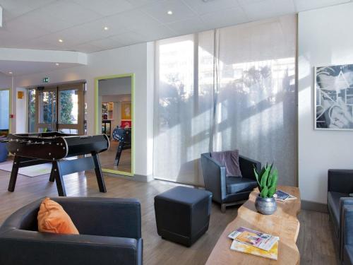 a living room with a couch and a piano at ibis Styles Cannes Le Cannet in Cannes