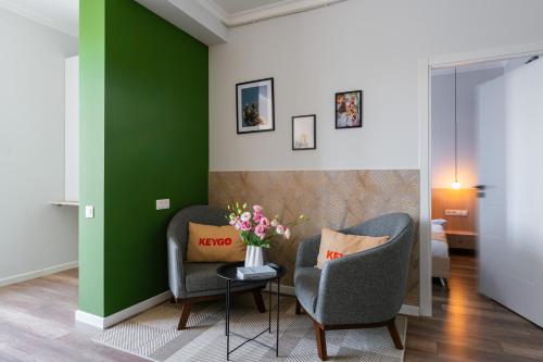 a living room with two chairs and a vase of flowers at Apartment KeyGo #0065 is the key to a comfortable location in Yerevan