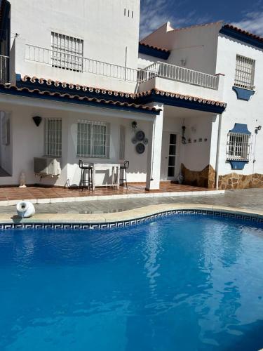 une villa avec piscine devant une maison dans l'établissement CASA RURAL MALAGA,VILLA FAMARA,10 personas,DESAYUNO ANDALUZ INCLUIDO EN EL PRECIO, à Malaga