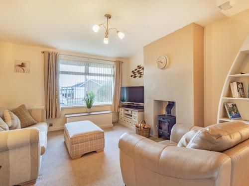 a living room with two couches and a tv at Gan Hyem in Beadnell