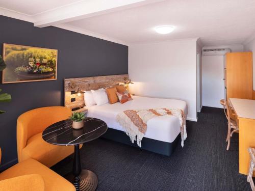 a hotel room with a bed and a table and chairs at ibis Styles Orange in Orange