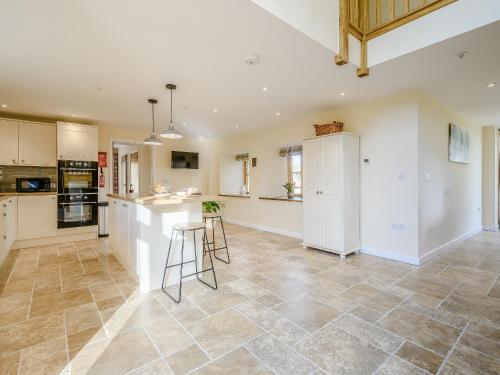 a kitchen with white cabinets and a tile floor at Owl Barn -- Uk30757 in Bream