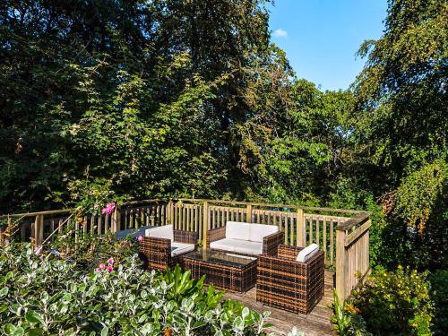a table and chairs in a garden with trees at Low Tide in Looe