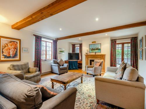 a living room with couches and a fireplace at White House Farm in Sedgeford