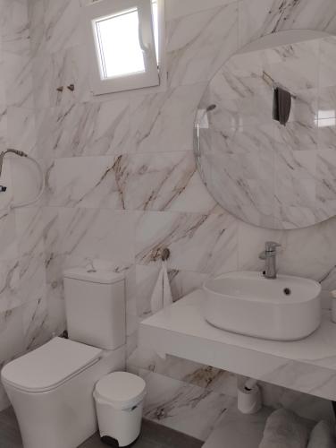 a white bathroom with a toilet and a sink at Apartamentos y Habitaciones KAI MARBELLA in Marbella