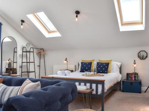 a bedroom with a bed and a blue couch at Elm House Studio in Christleton