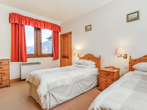 a bedroom with two beds and a window at Creagan Ruadh in Kintail