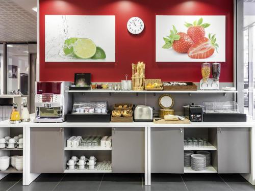 a kitchen with a counter with strawberries on the wall at Aparthotel Adagio Access Paris Clichy in Clichy