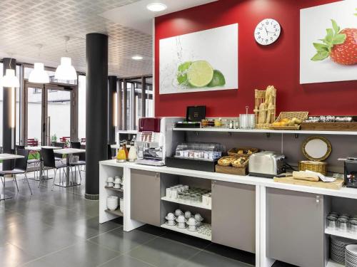 a fast food restaurant with a red wall at Aparthotel Adagio Access Paris Clichy in Clichy