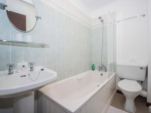 a white bathroom with a sink and a toilet at Apple Tree Cottage - E1800 in Scalby