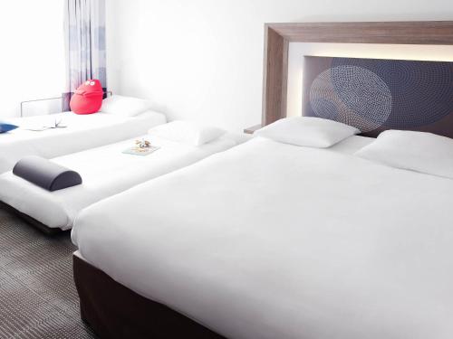 a row of beds in a hotel room at Novotel Marseille Centre Prado Vélodrome in Marseille