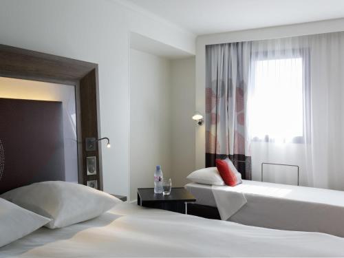 a hotel room with two beds and a window at Novotel Marseille Centre Prado Vélodrome in Marseille