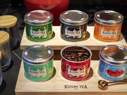 a group of canisters of kushkrit tea on a shelf at Novotel Marseille Centre Prado Vélodrome in Marseille
