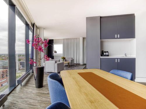 a kitchen and a dining room with a table and chairs at Mercure Hotel Amersfoort Centre in Amersfoort