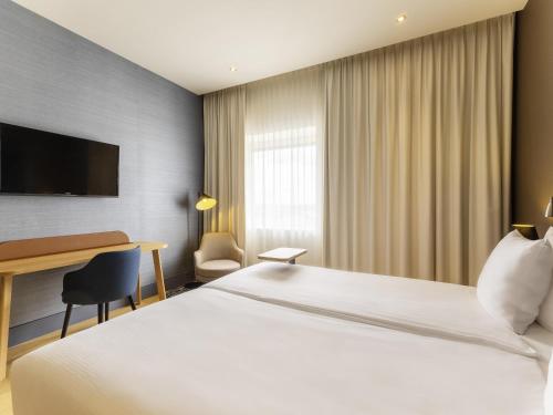 a hotel room with a bed and a desk at Mercure Hotel Amersfoort Centre in Amersfoort