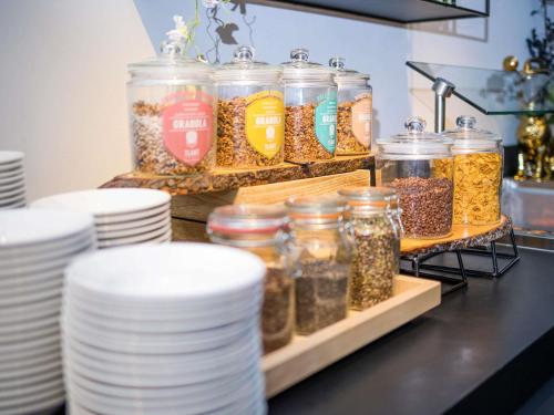 a counter with jars of food and plates and dishes at Mercure Hotel Amersfoort Centre in Amersfoort