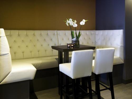 a bar with a table and two white chairs at Mercure Hotel Amersfoort Centre in Amersfoort