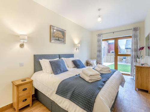 a bedroom with a bed with towels on it at Hollyhocks - Uk47975 in Woodford