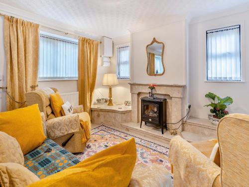 a living room with a fireplace and a couch at Pant Glas Cottage in Pontardawe