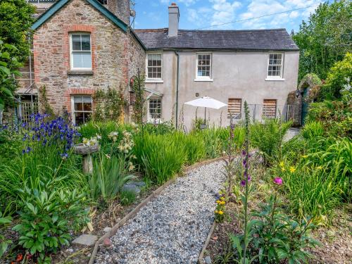 an old house with a garden in front of it at South Wing Cottage in Rumleigh