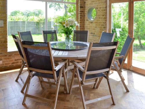 a dining room table with chairs and a vase of flowers at The Sanctuary in Little Chart