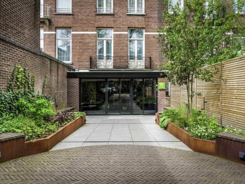 a brick building with a walkway in front of it at ibis Styles Amsterdam Amstel in Amsterdam