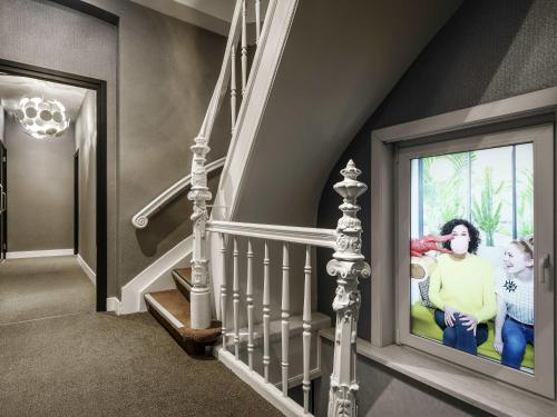 a hallway with a staircase with a picture on the wall at ibis Styles Amsterdam Amstel in Amsterdam