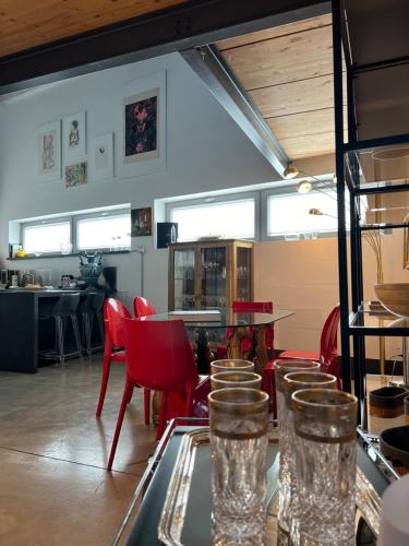 a restaurant with red chairs and glasses on a glass table at LoftDesign in Verona