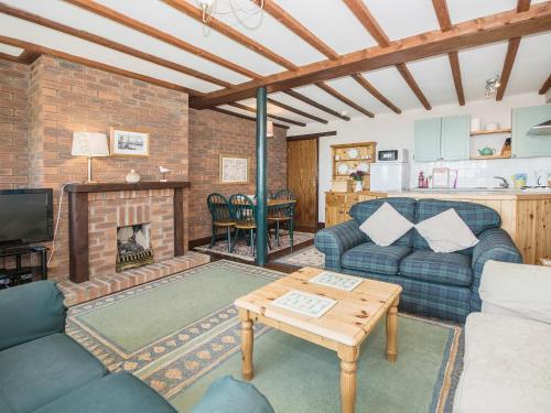 a living room with a couch and a fireplace at Meadowsweet Cottage - E1496 in Scalby