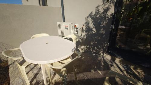 a white table and chairs in a room at Appartement T2 moderne 2 à 4 personnes in Lucciana