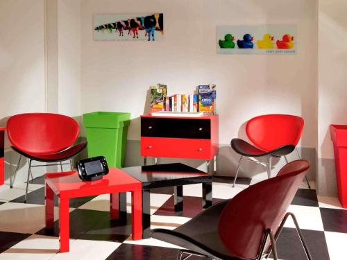 a room with red chairs and a table and a desk at ibis Styles Le Havre Centre in Le Havre