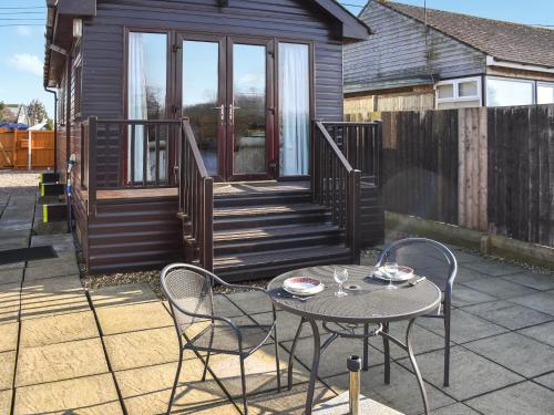 a patio with a table and chairs and a house at Rainbow's End in Brundall