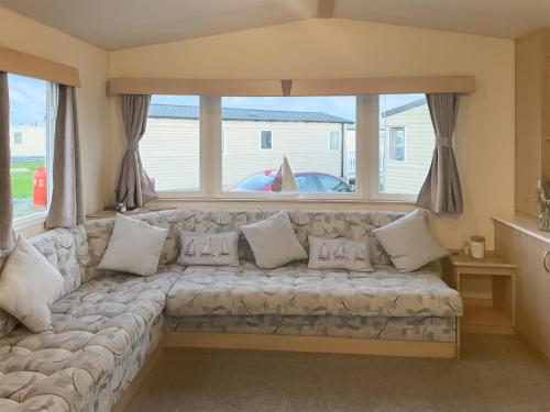 a couch in a living room with a large window at Sea Breeze in Heysham
