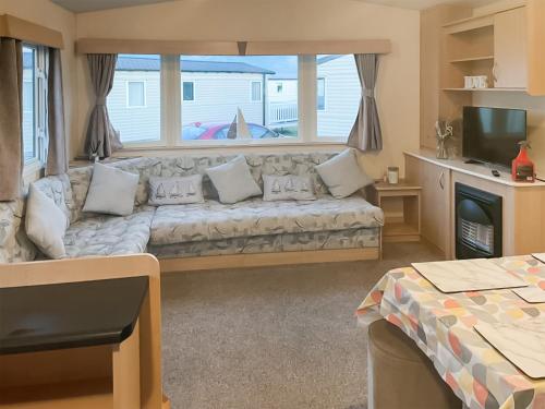 a living room with a couch and a window at Sea Breeze in Heysham