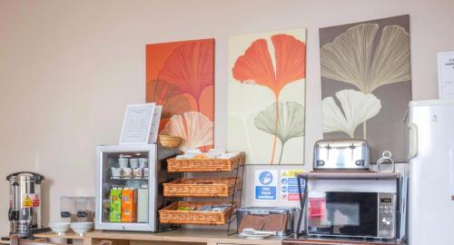 a kitchen with a counter with a microwave and baskets at Marlborough Hotel in Norwich