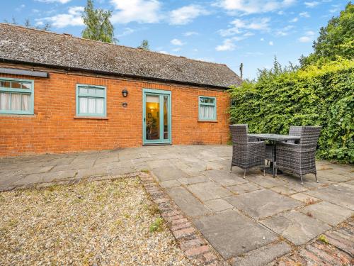 un patio con mesa y sillas frente a un edificio de ladrillo en The Stables - Uk44515, en North Thoresby
