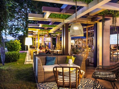 a patio with a couch and chairs and a table at Ibis Styles Regensburg in Regensburg