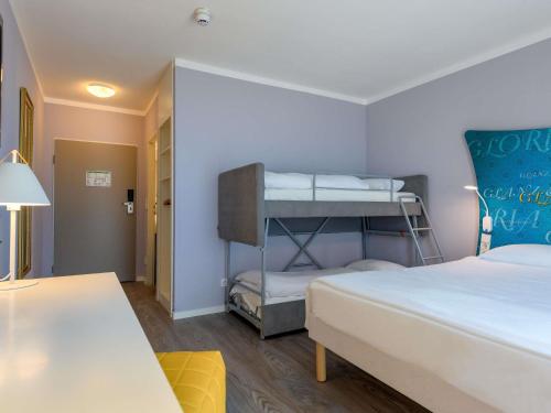 a bedroom with two beds and a bunk bed at Ibis Styles Regensburg in Regensburg