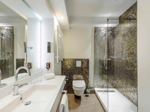 a bathroom with a sink and a toilet and a shower at Ibis Styles Regensburg in Regensburg