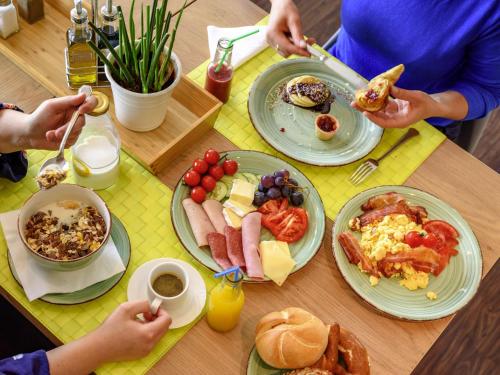 a table with plates of breakfast food on it at Ibis Styles Regensburg in Regensburg