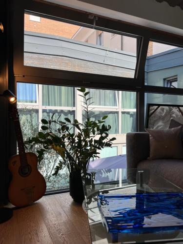 a living room with a guitar and a glass table at LoftDesign in Verona
