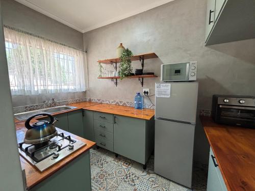 a kitchen with a refrigerator and a stove top oven at 59 van Heerden in Mokopane