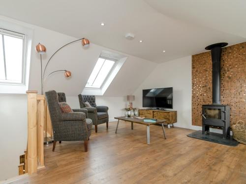 Una sala de estar con chimenea y televisión. en The Forge, en Roxby