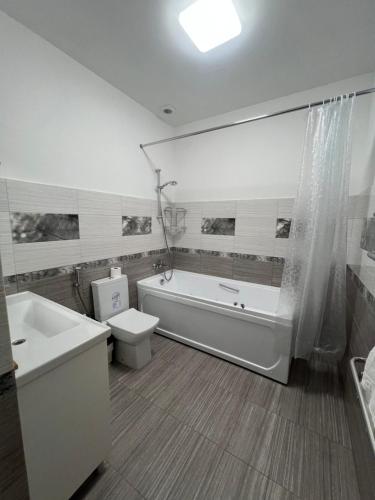 a bathroom with a tub and a toilet and a sink at Отель Преображенский in Odesa