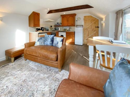 a living room with a couch and a table at Honeysuckle in Delabole