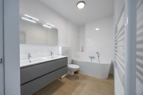 a bathroom with a tub and a sink and a toilet at Conrad City Stay - 176 in Ostend