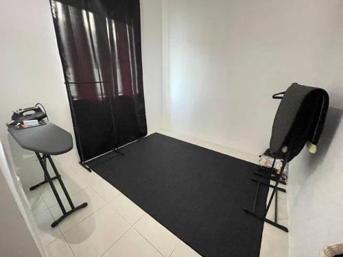 a room with a chair and a black door at Nazana Homestay in Batu Gajah
