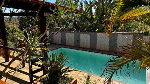 a swimming pool in a garden with plants at Casa Chácara Cambuquira in Cambuquira