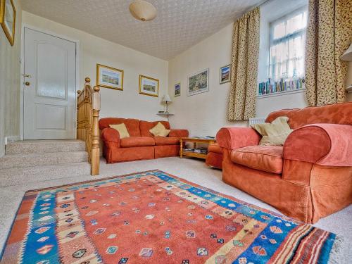 a living room with two couches and a rug at The Coach House in Birnam