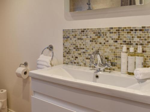 a bathroom with a white sink and a mirror at South Wing Coldharbour Park Farm in Rake